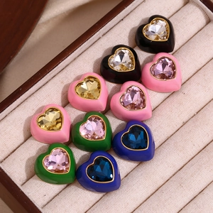 Gros plan de boucles d'oreilles cœur plaqué or 18K avec gemmes colorées dans un écrin
