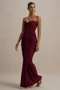 Detail of burgundy tube dress featuring elegant ruching and draped fabric design