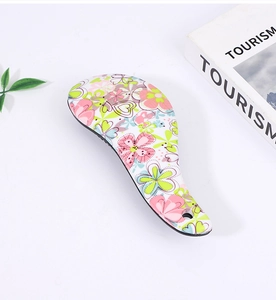 Detail of detangling hair brush featuring floral pattern and air cushion bristles