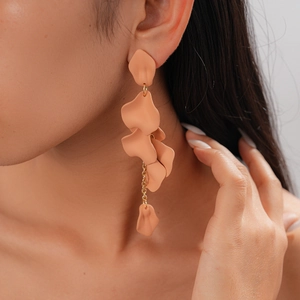 Detail of pink acrylic petal tassel earrings with gold chain link on model