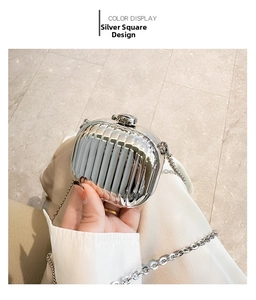 Close-up of a silver metallic mini evening bag with textured vertical wave pattern