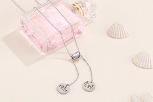 Detail of silver heart-shaped slide clasp and family silhouette pendants on necklace