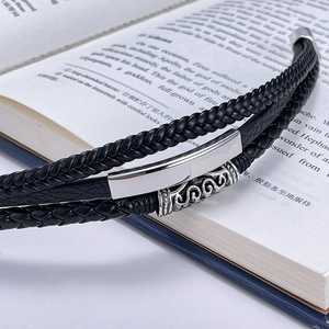 Macro shot of multi-layer braided black leather bracelet with vintage metal details