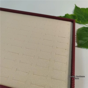 Detail view of cream velvet jewelry display tray with slots for 100 rings and earrings