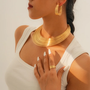 Goldenes mehrlagiges Set aus Halskette, Ohrringen und Ring an einem Model getragen