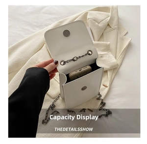 Detailed interior of a white leather chain bag showing phone storage and magnetic clasp