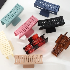 Flat lay of square matte hair claws in multiple colors with internal metal spring mechanism