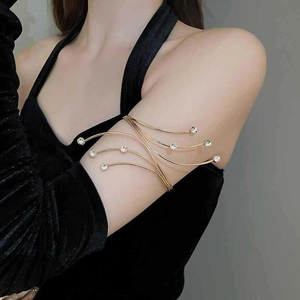 Detail of elegant gold rhinestone upper arm cuff with flowing lines on model