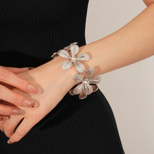 Makro-Detail des silbernen Blumenarmbands mit Strass-Mitte und strukturierter Metalloberfläche