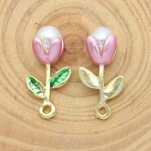Close-up of handmade pink tulip charms with gold base and pearl inlay for DIY jewelry