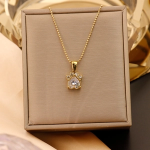 Gros plan du pendentif patte de chat doré avec zircon en cœur sur boîte à bijoux