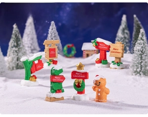 Close-up of miniature resin Christmas road signs and a gingerbread man in a snowy scene