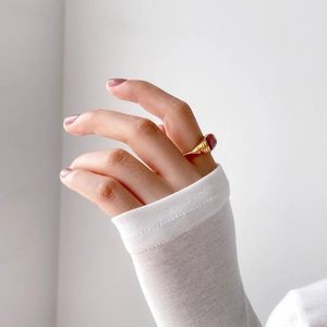 Detailed macro view of a vintage gold ring with a red oval ruby worn on the finger