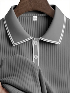 Detailed view of grey striped knit polo shirt with contrast collar and fabric texture