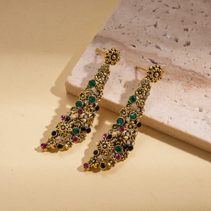 Close-up of vintage flower earrings with multicolored rhinestones and antique gold finish