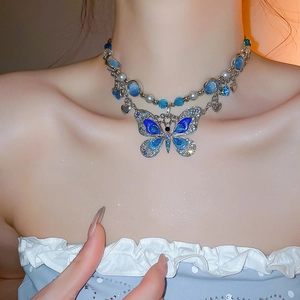 Détail du collier pendentif papillon bleu avec perles et détails en strass