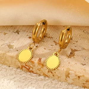 Boucles d'oreilles créoles dorées avec pendentif cœur sur plateau en pierre et soie