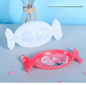 Detail showing candy shaped silicone mold with a pink resin tray on a blue background