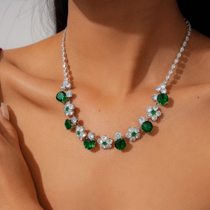 Detail view of emerald zircon floral necklace on model showing luxury craft