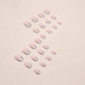 Faux ongles ovales roses avec pointes French pailletées argentées sur fond neutre