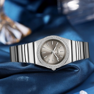 Silver luxury women's watch with diamond bezel and date display on blue silk