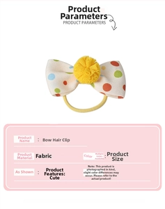 Detailed view of colorful polka dot fabric bow clip with soft yellow pompom decoration