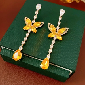 Detailed close-up of butterfly drop earrings with yellow and white zircon stones