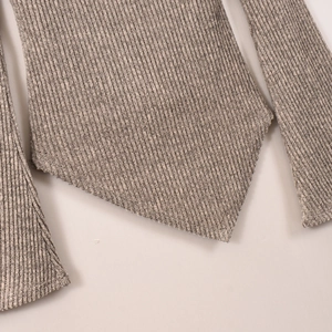 Dettaglio del top grigio in maglia a coste con orlo a V e polsini strutturati della manica