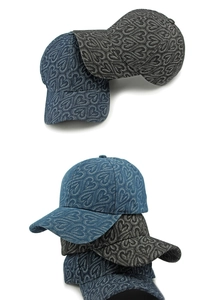 Détail de casquette de baseball en denim avec motif jacquard cœur en bleu et anthracite