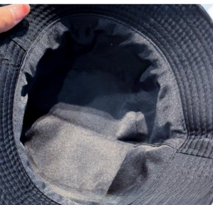 Detail view of the breathable fabric and reinforced stitching inside this black sun hat