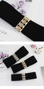 Detail view of wide elastic waist belt with textured gold and silver metal oval buckles
