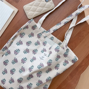 Macro view of vintage floral cotton tote bag with dual handles and fabric label detail