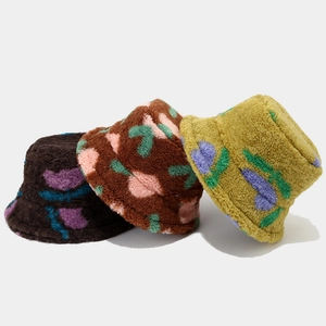 Three plush bucket hats with floral patterns in brown and yellow for winter warmth
