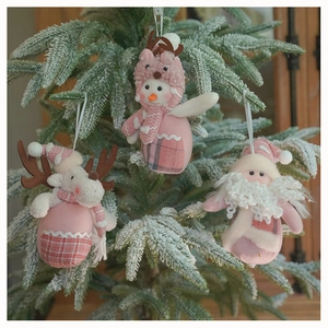 Detailed plush Christmas ornaments featuring pink reindeer and Santa on a snowy tree