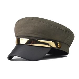 Detail of a chic military style baker boy hat with gold metal band and leather brim
