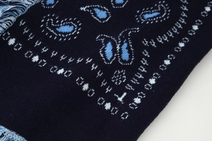 Close-up of navy blue knit scarf with light blue and white paisley patterns
