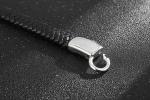 Détail macro du bracelet en cuir tressé noir pour hommes avec fermoir en argent