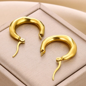 Macro shot of gold stainless steel earrings featuring unique irregular lava texture