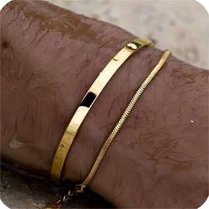 Men's double-layered gold bracelet featuring a flat cuff and sleek snake chain