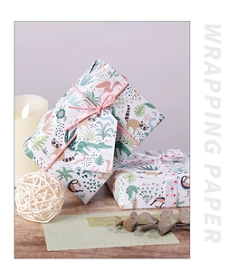 Close-up of jungle animal pattern wrapping paper with raccoons and birds on gift boxes