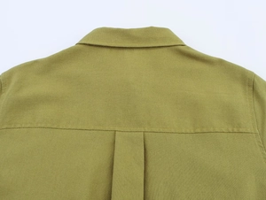 Detailed view of olive green linen shirt neckline with fine cotton texture and stitching