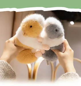 Close-up of soft plush guinea pig toys in orange and grey colors held in hands