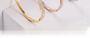 Detail of gold and rose gold bangles with double-row micro-pave cubic zirconia crystals