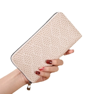 Elegant beige woven long zipper wallet for women held by hand against white background