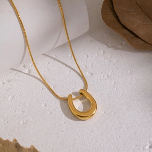 Minimalist U-shaped horseshoe pendant necklace in 18K gold plating on white stone