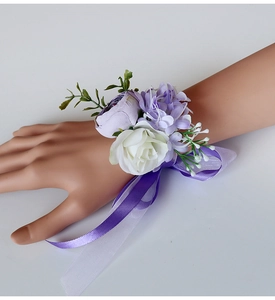 Detail of light purple and white rose wrist corsage with long silk ribbon for weddings