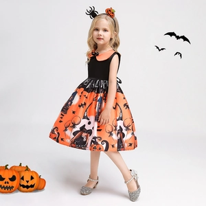 Detail of girls Halloween dress featuring black and orange pumpkin and witch pattern