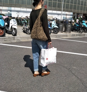 Dettaglio di una borsa tote grande con stampa leopardata portata a spalla