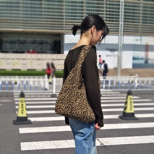 Vista in strada di una donna con una borsa tote grande in tela con stampa leopardata