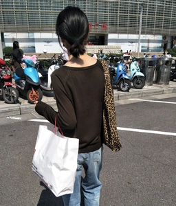 Vista street style di una borsa tote in tela con stampa leopardata indossata da una donna